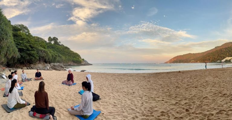 Photographie d'une méditation de groupe sereine sur la plage, célébrant la connexion, la présence et l'esprit des fêtes. La méditation est une étape essentielle pour devenir bouddhiste.