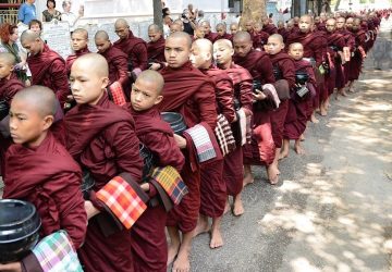 Le bouddhisme est une religion où les moines se conscrent à la méditation. Ici, les Jeunes moines bouddhistes en Birmanie, vêtus de robes marron et marchant pieds nus avec des bols noirs pour les offrandes.