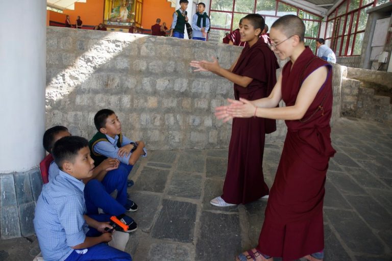 Des élèves tibétains apprenant le débat monastique au couvent de Dolma Ling, développant leur pensée critique et leur logique.